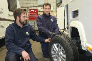 Salop Leisure service engineers Nick Wood and Tom Hancock check the tread on a touring caravan tyre during a service.