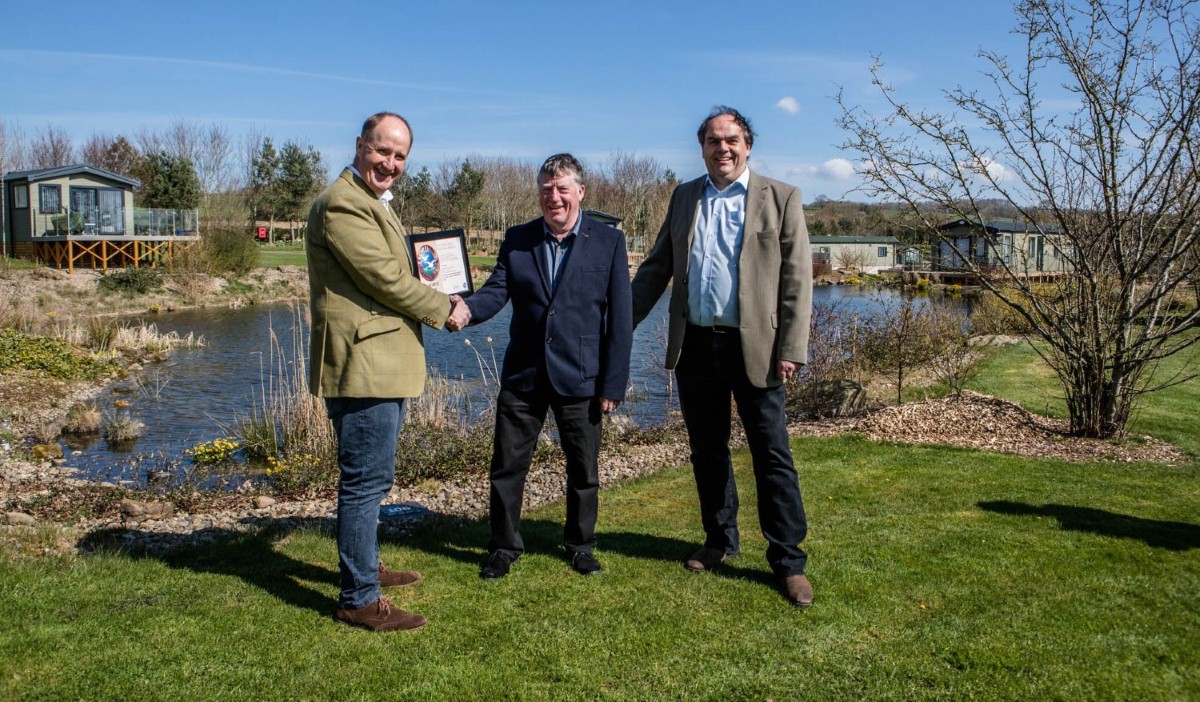 Kevin Hollinrake MP (left) congratulates long-serving park manager Trevor Jones and business owner Mark Goodson