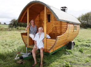 Tony Goulden and Merja Stock sit outside their caravan sauna
