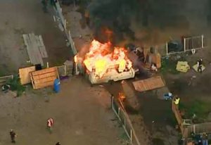 The caravan was set ablaze to stall the line of advancing riot police (Pictures: Channel 4 News)