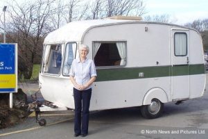 Frank Holgate's wife Judy poses with the 50-year-old self-built caravan he was reunited with