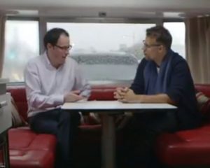 Presenter, Richard Bacon, and statistician, Nate Silver, conduct an interview inside a moving caravan