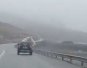 The moment a caravan was blown off a notoriously windy mountain road has been caught on film
