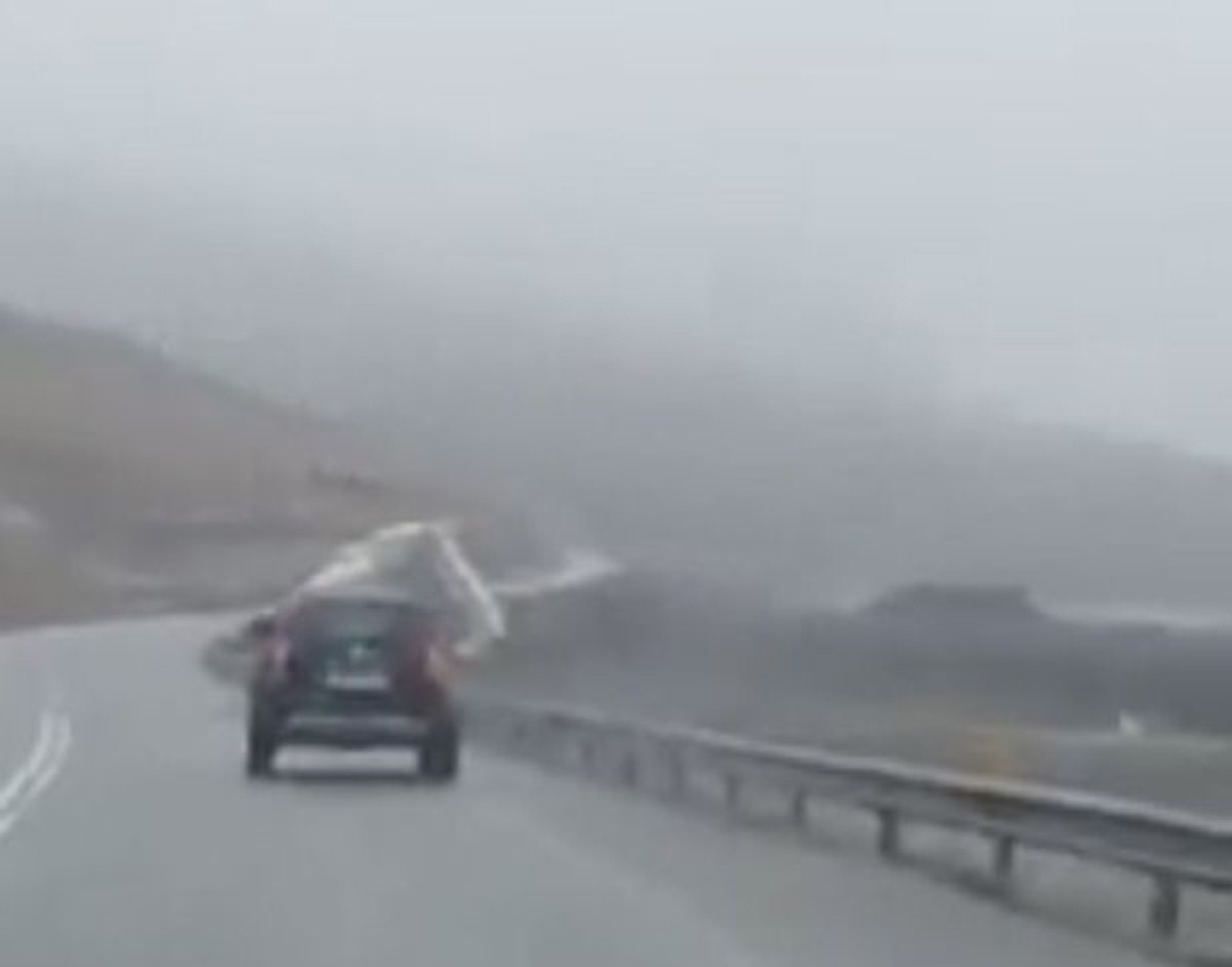 The moment a caravan was blown off a notoriously windy mountain road has been caught on film