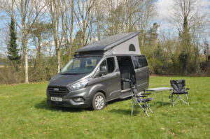 Ford Nugget with roof popped and camping furniture set up