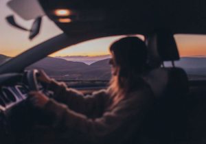 Woman driving a car at sunset