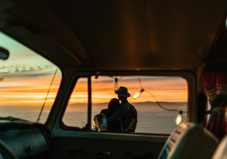Couple enjoying the sunset just outside their van