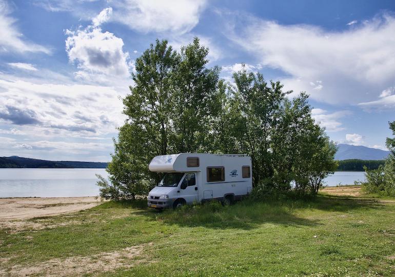 A motorhome parked by a bush