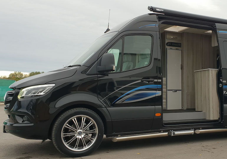 A van conversion with the door open, exposing a fridge