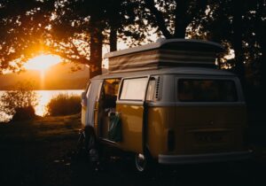 A campervan with a pop-top roof parked up in the evening light