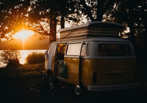 A campervan with a pop-top roof parked up in the evening light