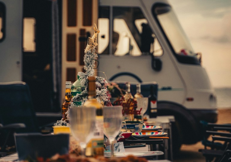 Wine glasses and a Christmas tree with a motorhome in the background