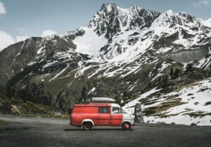 A leisure vehicle parked up against a backdrop of snowy mountains