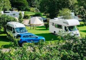 Motorhomes and a tent pitched up in a field