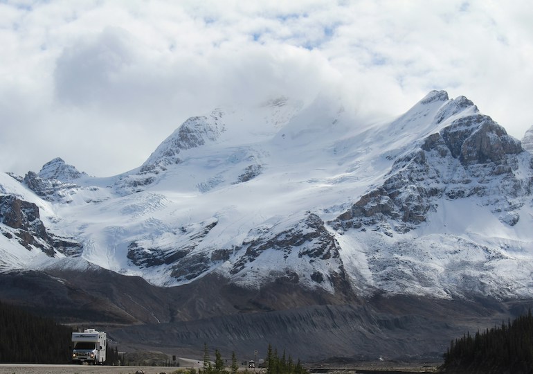 Motorhome with snowy mountains towering behind
