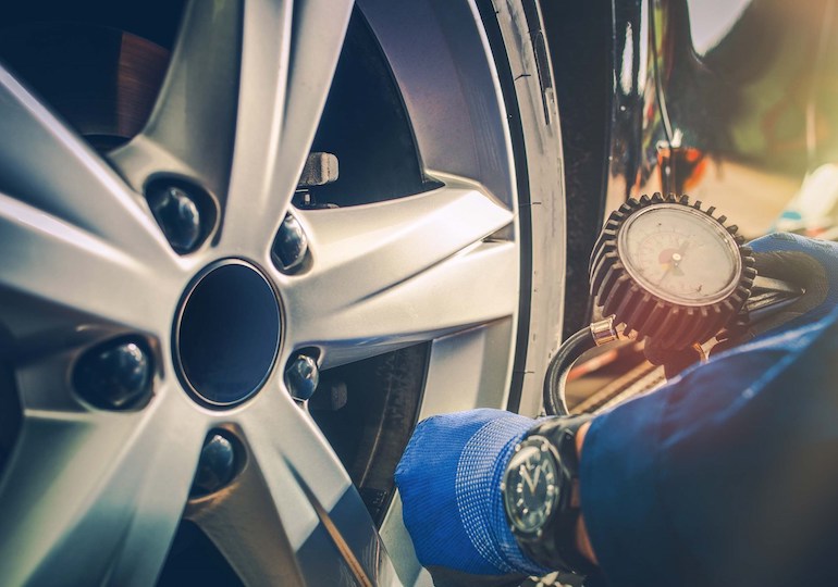 Someone measuring the pressure on a tyre