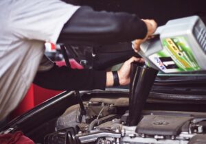 A man topping up fluids in a car