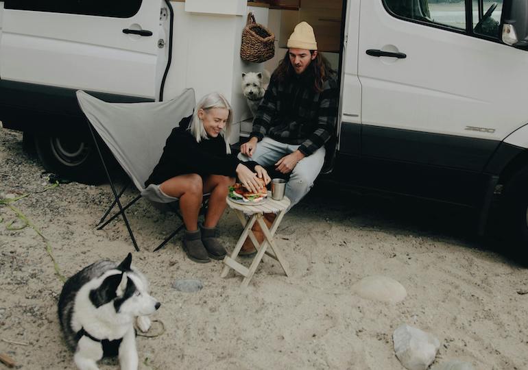 Dogs and their owners sitting outside a motorhome