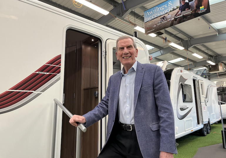 Tony Bywater standing on the steps of a caravan at a show